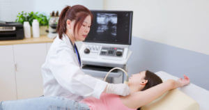 Woman lymph ultrasound examination to check for thyroid cancer radiation exposure.